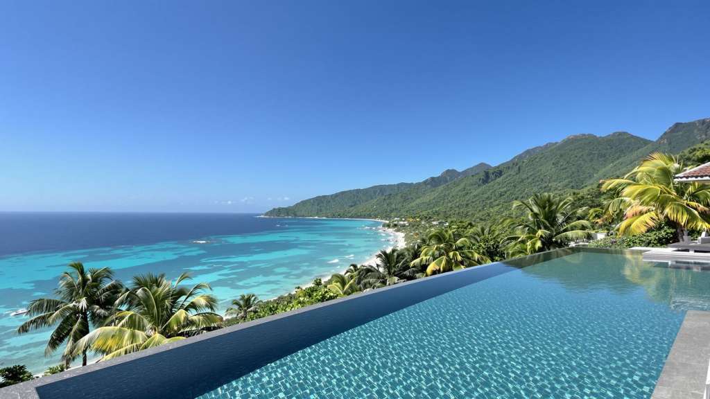 Luxury villa with infinity pool overlooking Phuket's ocean and mountains.