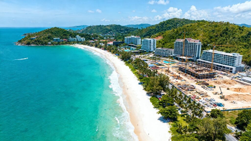 Phuket coastline with resorts and construction, indicating investment boom.