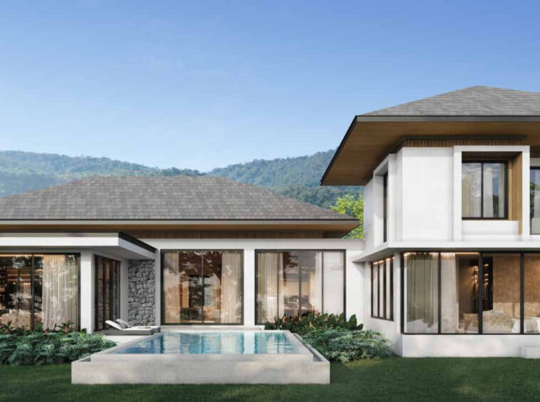 Contemporary white two-story house with large glass walls, a rectangular pool, and a landscaped lawn against a mountainous backdrop
