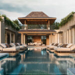 Luxurious modern villa with a long rectangular pool, white cushioned loungers, and a central wooden gazebo.