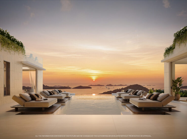 Sunset over the calm sea viewed from an infinity pool deck with lounge chairs at a modern resort