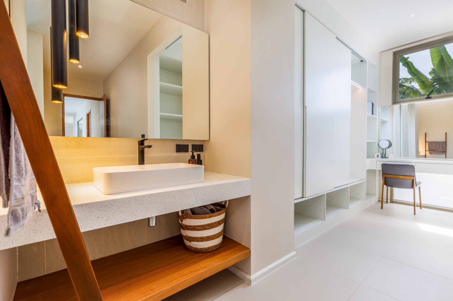 Modern bathroom with a white vessel sink, black faucet, and large mirrored cabinet above a speckled countertop.