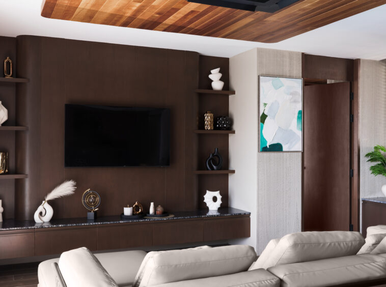 Modern living room with dark wood walls, wall-mounted TV, open shelves of vases and sculptures, and a beige sectional facing the screen.