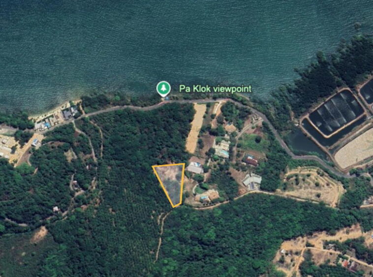 Aerial view of a coastal area with a triangular plot outlined in orange among trees, near Pa Klok viewpoint on the coast.