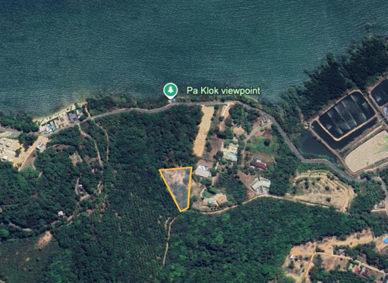 Aerial view of a coastal area with a triangular plot outlined in orange among trees, near Pa Klok viewpoint on the coast.