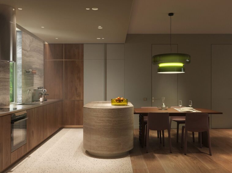 Modern kitchen with wood cabinets, an island, and a large green pendant light over a dining table set for four to six people in warm lighting.