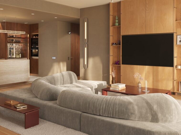 Open-plan living area with a large gray sectional sofa facing a built-in wooden media wall and flat-screen TV, surrounded by shelves and decor.