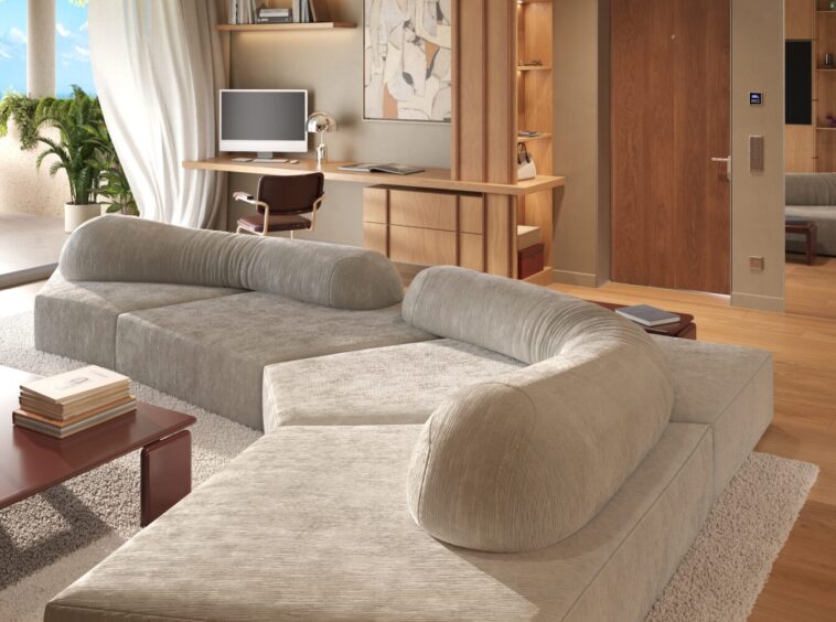 Modern living room with a light gray sectional sofa on a cream shag rug, wooden coffee table and shelves, and large windows with sheer curtains.