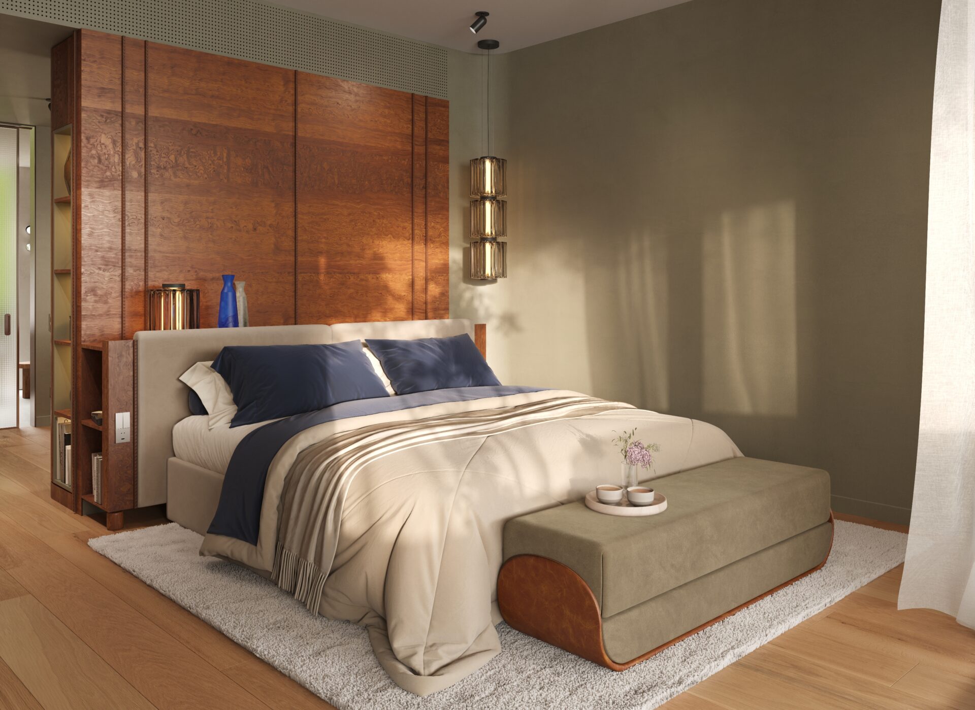 Bedroom with a beige upholstered bed, navy pillows, and a large wood panel headboard against a tan wall; pendant light and ottoman at the foot.