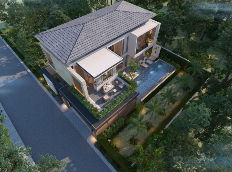 Aerial view of a modern two-story villa with a sloped tiled roof, glass walls, and a rectangular pool surrounded by lush greenery and trees.