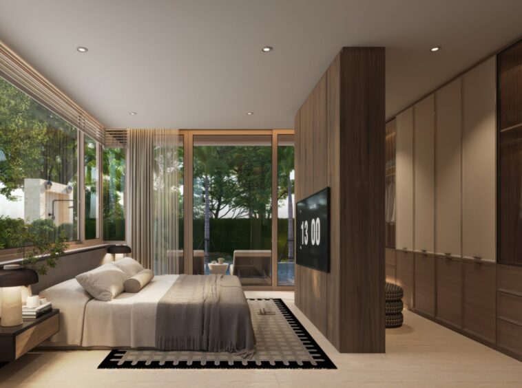 Modern bedroom with floor-to-ceiling glass windows opening to a green garden, a king bed, and a wooden partition with a wall-mounted TV.