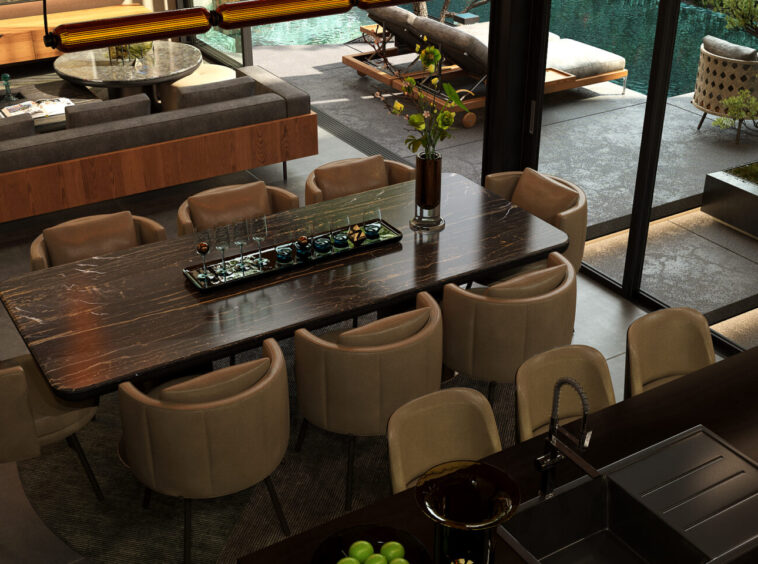 Luxurious open-plan dining area with a dark marble table and beige chairs, overlooking a pool deck through glass walls.
