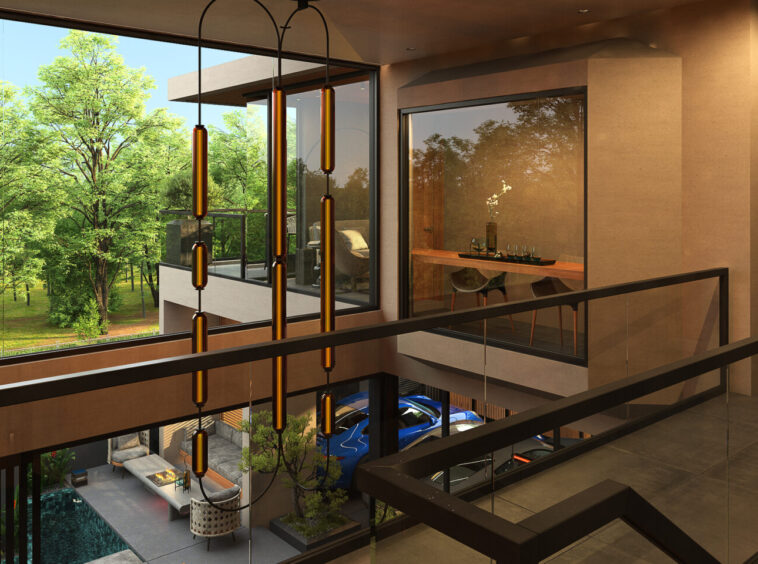 Open, multi-level atrium of a modern building with glass railings and amber pendant lights, overlooking a courtyard with trees and a blue car below.