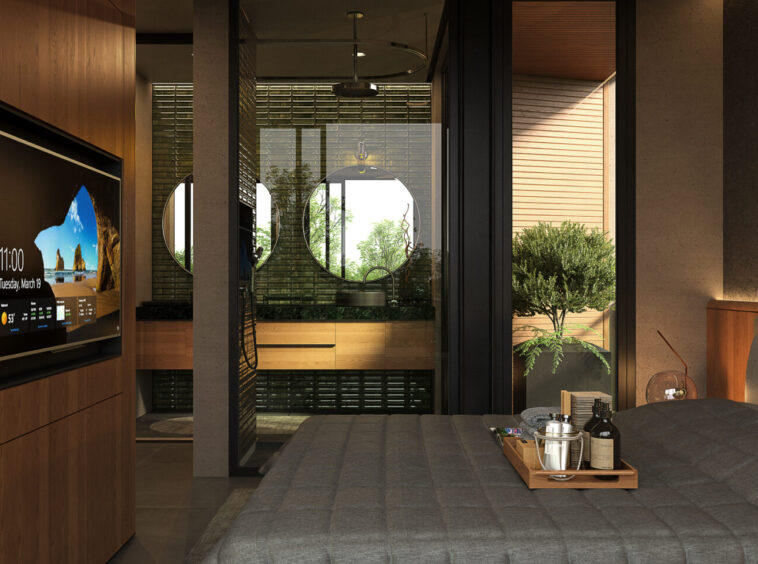 Luxurious hotel bedroom with a large gray bed, wooden panels, and a tray of drinks at the foot of the bed