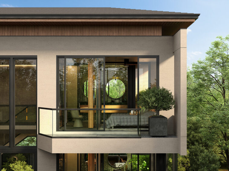 Contemporary apartment balcony with glass railing and greenery, showing a living space inside with a circular window view of trees outside.