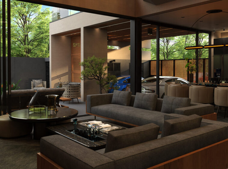 Modern open-plan living area with gray sofas, glass walls, and a view of a courtyard and cars outside in a contemporary home.
