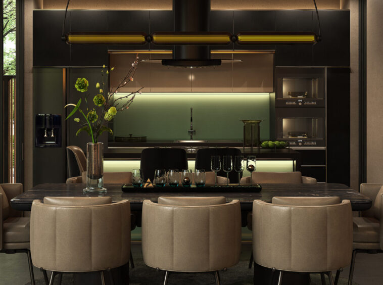 Modern kitchen and dining area with a dark island, green backsplash, and a long table set with glassware and beige chairs surrounding it.