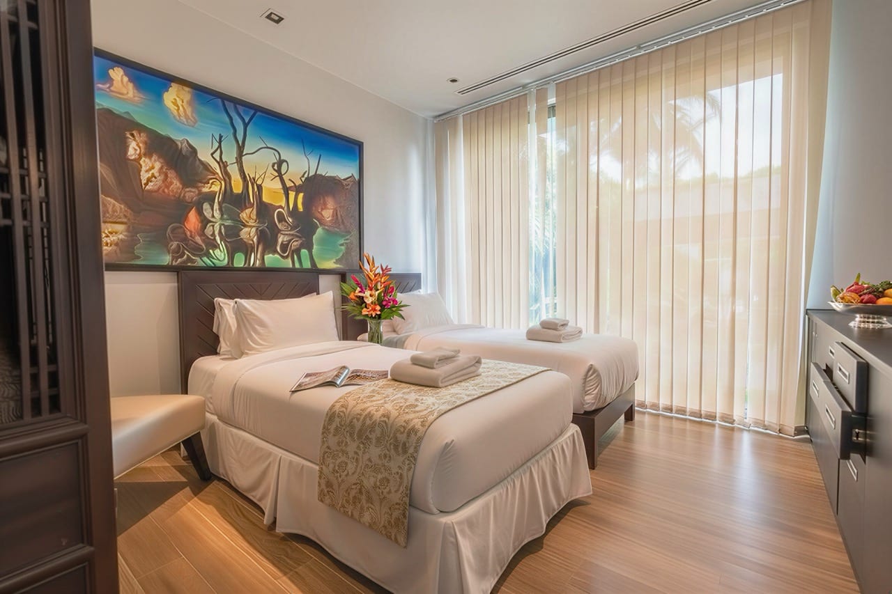 Hotel room with two twin beds, white bedding, and a large colorful painting above the headboards.