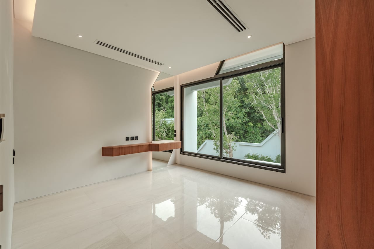 Bright minimal room with a glossy white floor, large windows, and a floating wooden desk along the wall.